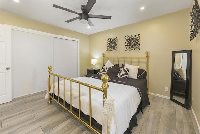 bedroom featuring ceiling fan, a closet, and light hardwood / wood-style floors