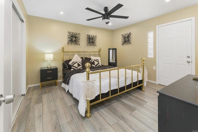 bedroom with ceiling fan, baseboards, and wood finished floors