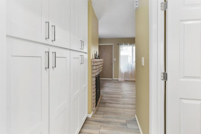 corridor with wood finish floors and baseboards