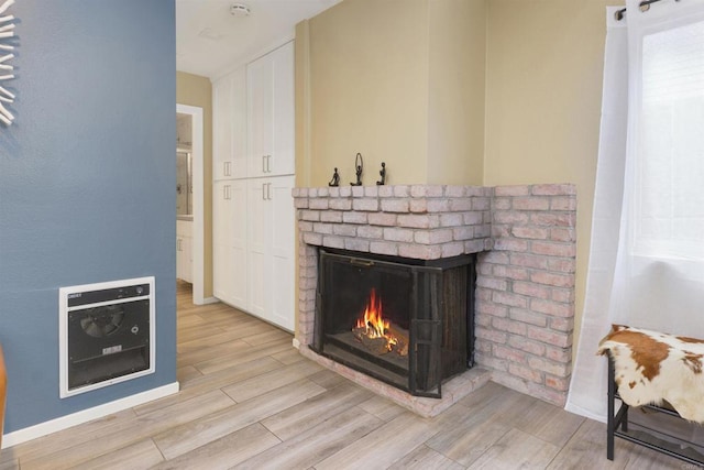 room details with a brick fireplace, heating unit, and wood finished floors