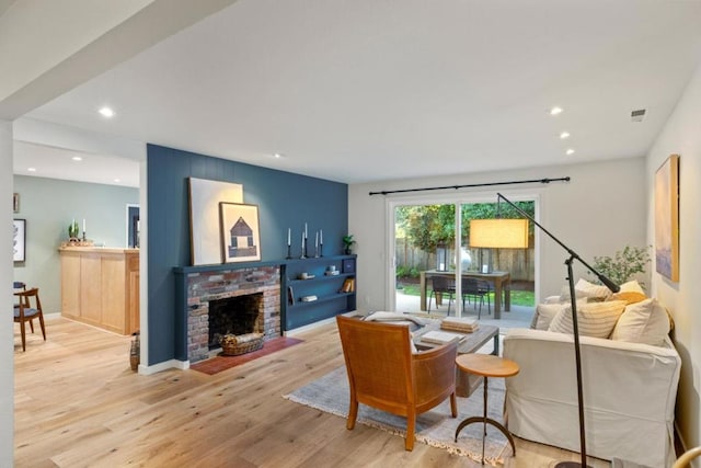 living room featuring a fireplace and light wood-type flooring