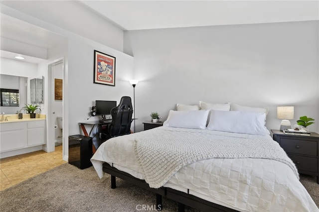 bedroom with light tile patterned flooring and connected bathroom