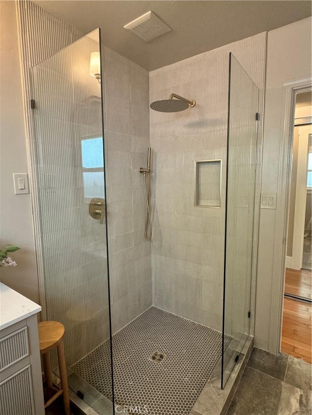 bathroom with tiled shower and vanity