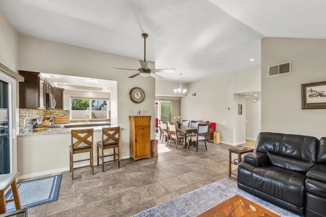 living room featuring vaulted ceiling and ceiling fan with notable chandelier