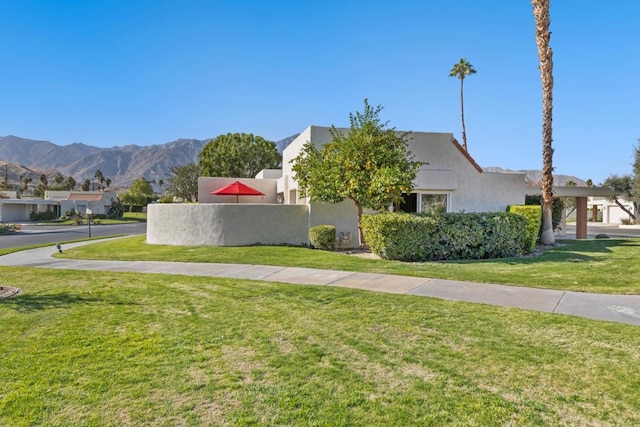 exterior space with a mountain view and a front yard