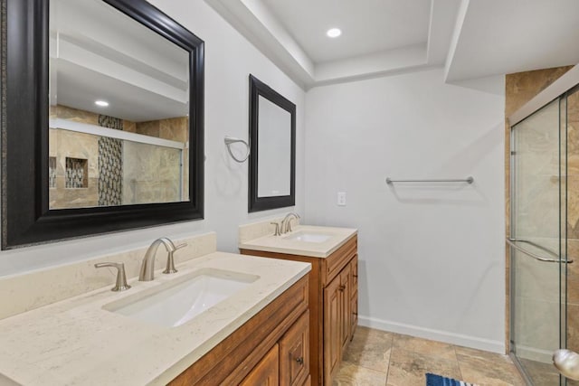 bathroom featuring a shower with shower door and vanity