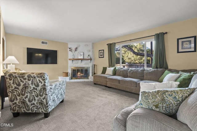 living room with a brick fireplace and carpet floors