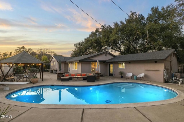 pool at dusk with a gazebo, an outdoor living space, and a patio