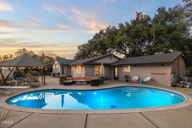 pool at dusk featuring a fenced in pool, a patio, a gazebo, an outdoor living space, and a diving board