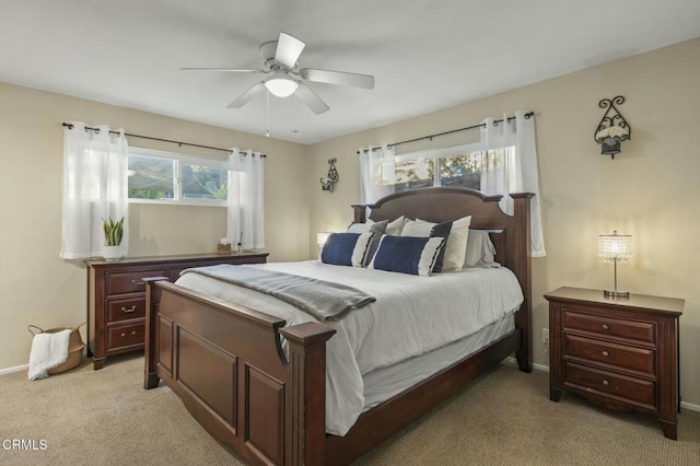 bedroom with light carpet, ceiling fan, and baseboards