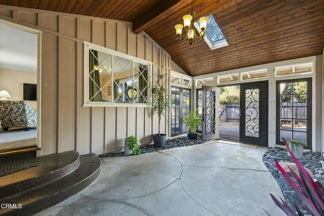 sunroom / solarium featuring lofted ceiling with skylight, wood ceiling, and a notable chandelier