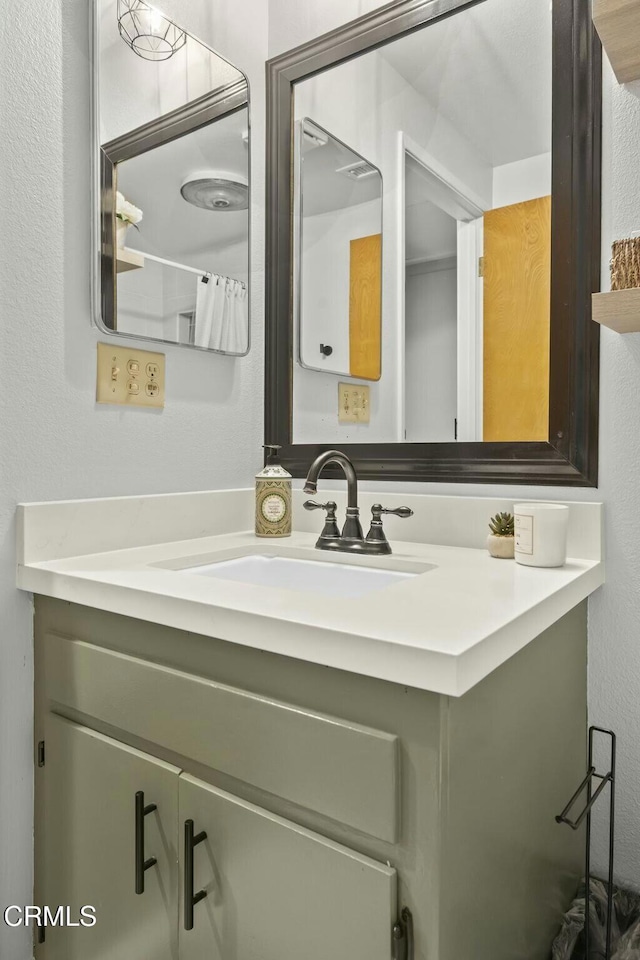 bathroom featuring a textured wall and vanity