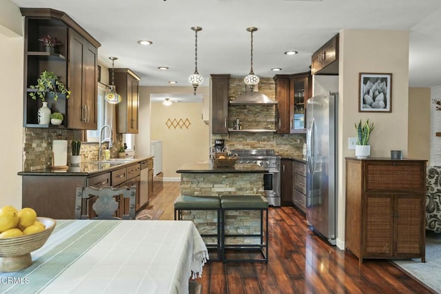 kitchen with dark countertops, open shelves, a sink, stainless steel appliances, and dark wood-type flooring