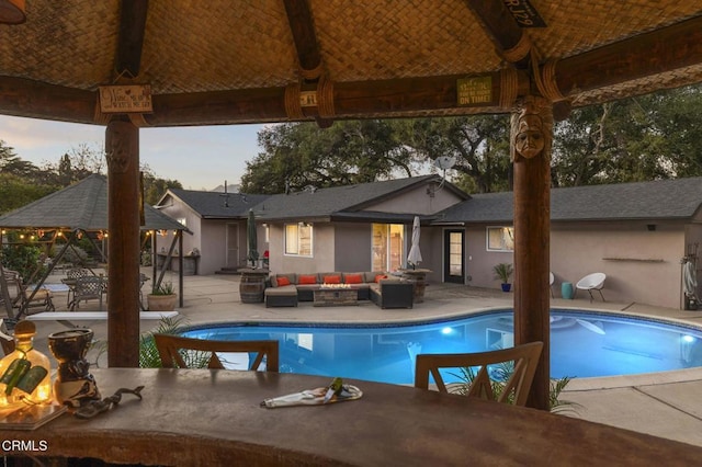 pool with a patio area, outdoor lounge area, and a gazebo