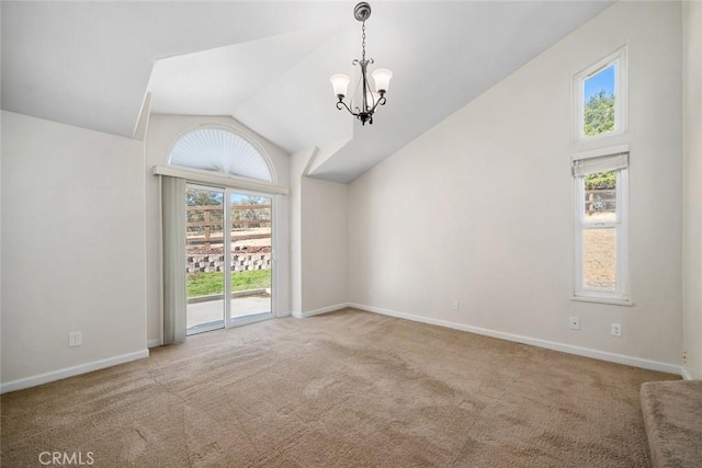 carpeted spare room featuring vaulted ceiling and a notable chandelier