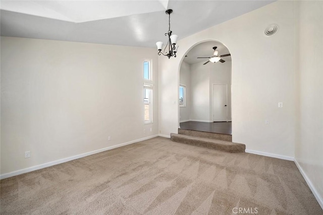 spare room featuring carpet floors and ceiling fan with notable chandelier