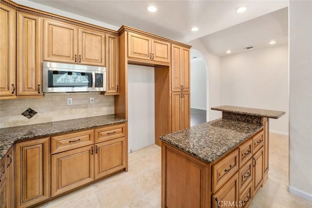 kitchen featuring tasteful backsplash and dark stone counters