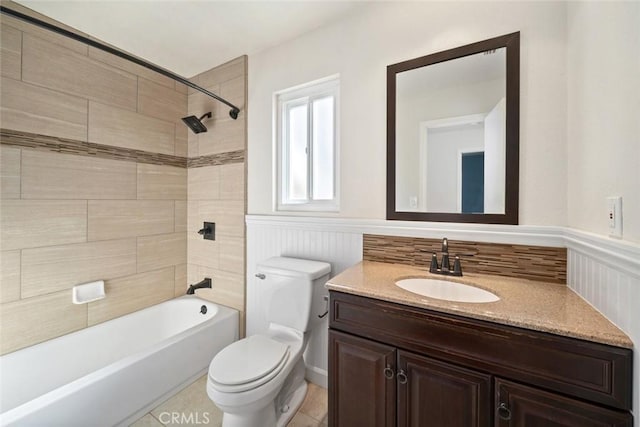 full bathroom with toilet, tiled shower / bath, and vanity