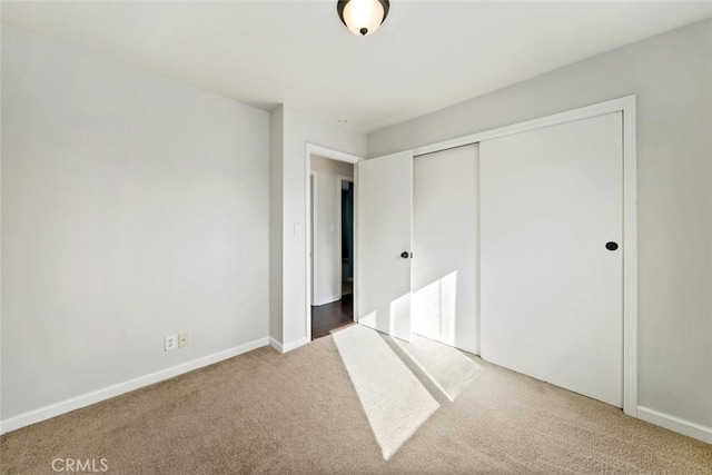 unfurnished bedroom featuring carpet floors and a closet