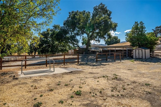 view of yard with a rural view and a shed