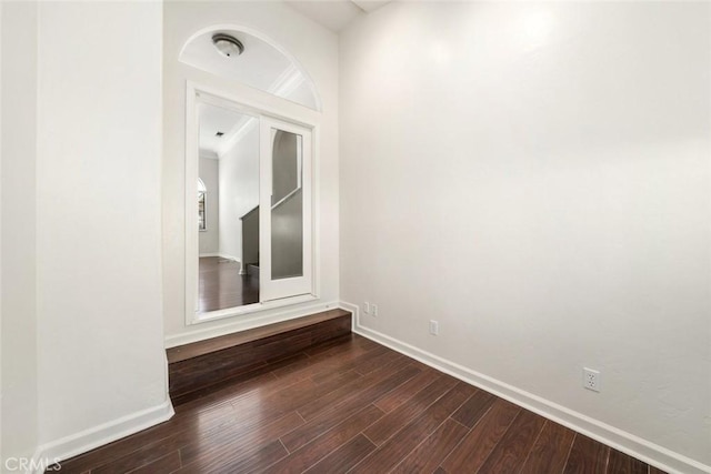 spare room featuring dark hardwood / wood-style flooring and crown molding