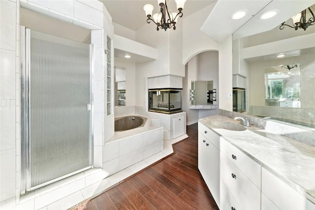 bathroom featuring an inviting chandelier, separate shower and tub, and vanity