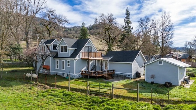 rear view of property with a balcony and a lawn