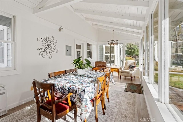 sunroom / solarium with electric panel, lofted ceiling with beams, and an inviting chandelier