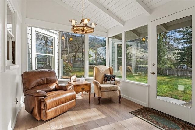 sunroom with lofted ceiling with beams and a chandelier