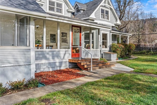 view of front of property featuring a front lawn and a sunroom