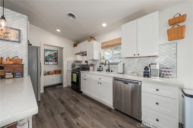 kitchen featuring white cabinets, pendant lighting, appliances with stainless steel finishes, and sink