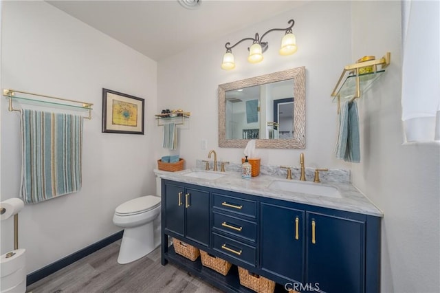 bathroom featuring toilet, vanity, and hardwood / wood-style flooring