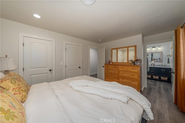 bedroom featuring connected bathroom and dark hardwood / wood-style flooring