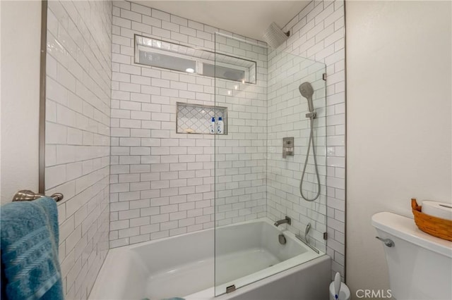 bathroom featuring tiled shower / bath combo and toilet