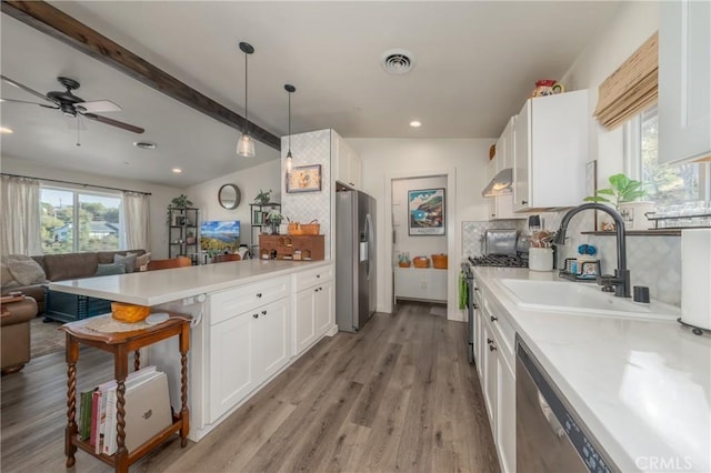 kitchen with stainless steel appliances, decorative backsplash, lofted ceiling with beams, white cabinets, and sink