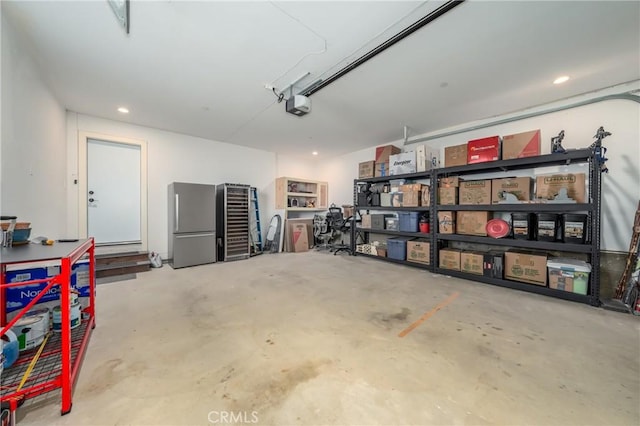 garage featuring stainless steel fridge and a garage door opener