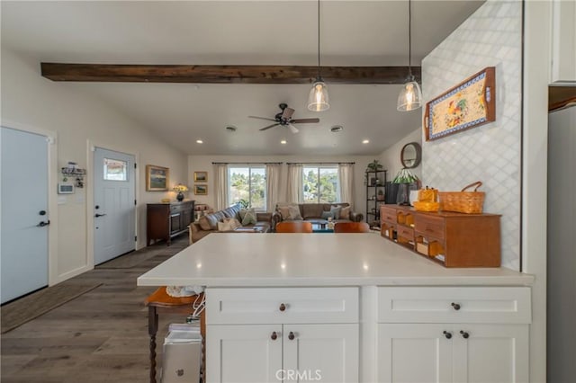 kitchen featuring white cabinetry, ceiling fan, dark wood-type flooring, vaulted ceiling with beams, and pendant lighting