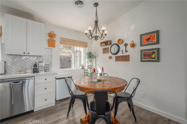 dining area featuring wood-type flooring and a notable chandelier