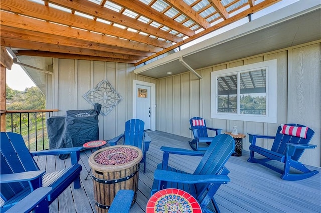 wooden terrace with a pergola and an outdoor fire pit