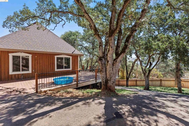 view of side of property featuring a swimming pool side deck