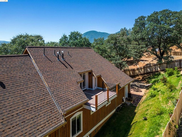 view of property exterior with a mountain view and a balcony