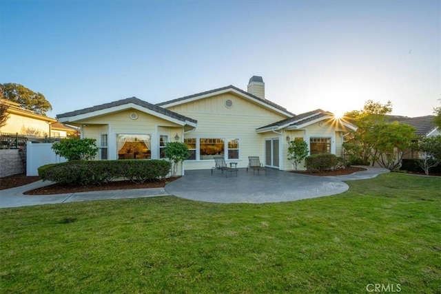 rear view of property with a patio area and a lawn