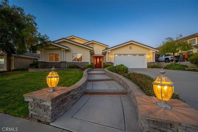 view of front of property with a garage and a yard