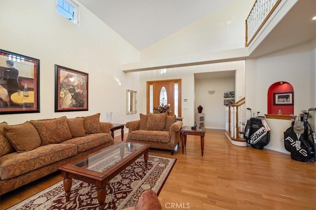 living room featuring high vaulted ceiling and light hardwood / wood-style floors