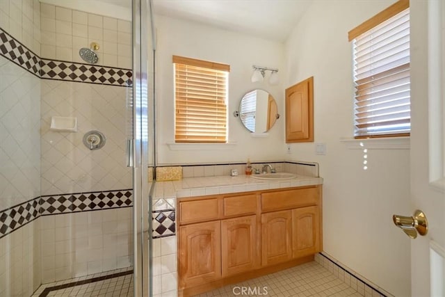 bathroom featuring vanity, tile patterned flooring, and a shower with door