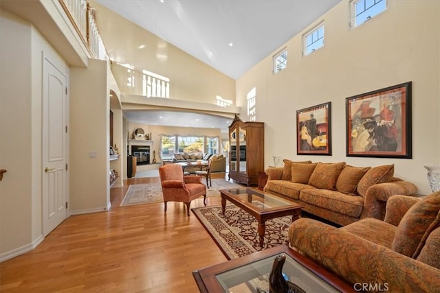 living room with high vaulted ceiling and light hardwood / wood-style floors