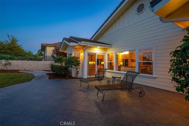 back house at dusk with a patio