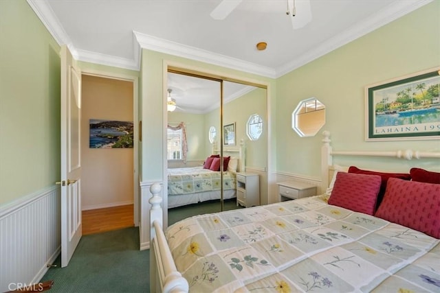 carpeted bedroom with ceiling fan, ornamental molding, and a closet