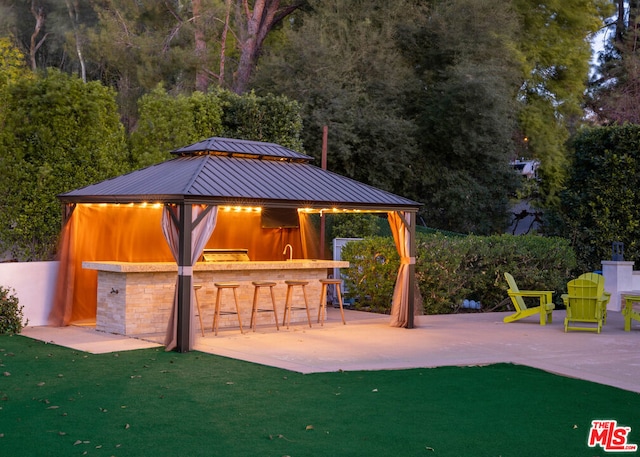 view of patio with exterior bar and a gazebo