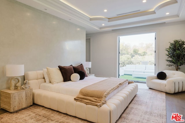 bedroom featuring light wood-type flooring, access to exterior, a tray ceiling, and ornamental molding